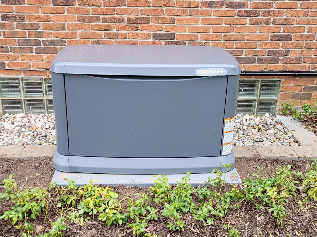 Generac standby generator installed beside a brick home by 3D Electric