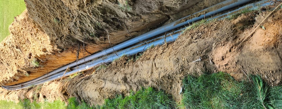 Underground service conduit in an open trench